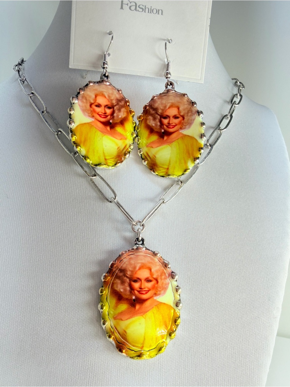 Dolly Parton necklace and earrings set with yellow background and silver chain #